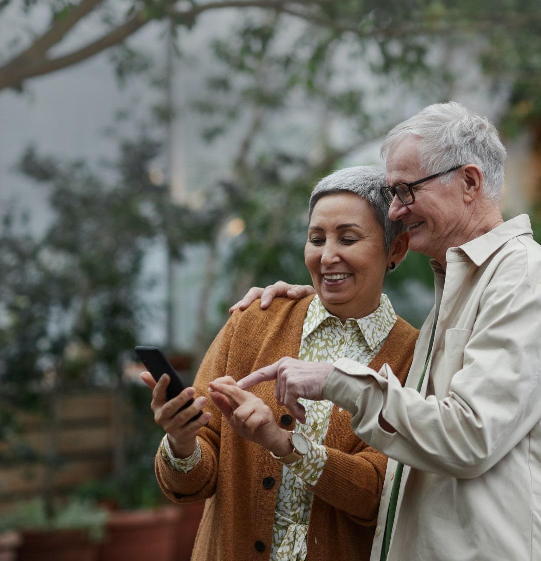 Abuelitos mirando y apuntando un celular